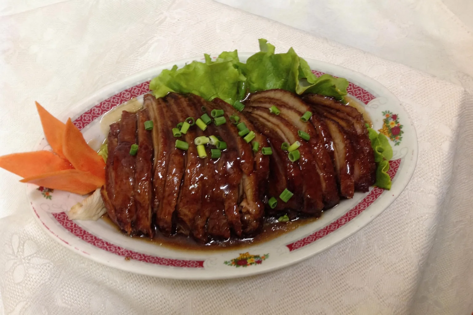 Duck on an oval dish with a pink border