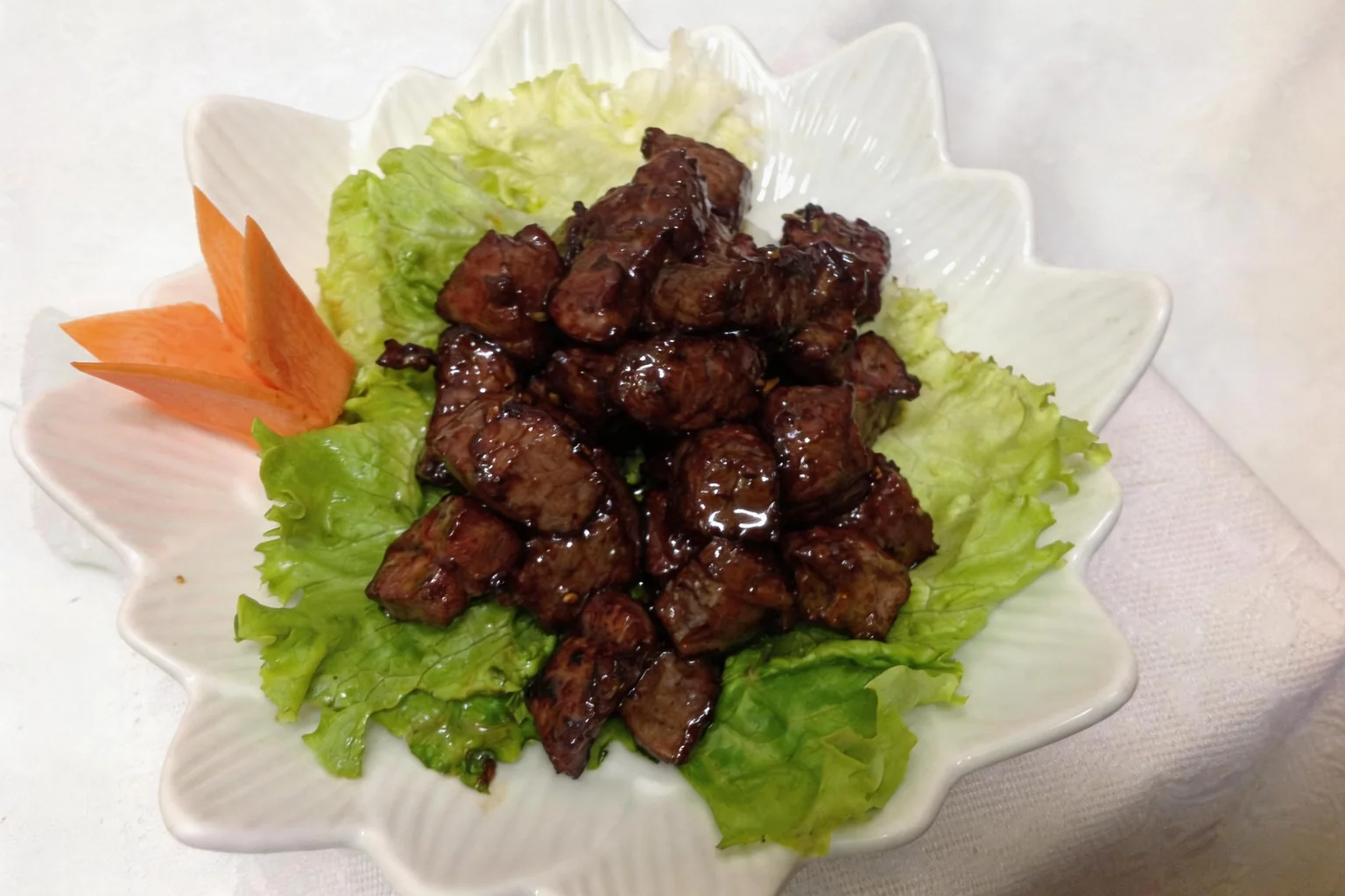 Beef in a white flower-shaped bowl
